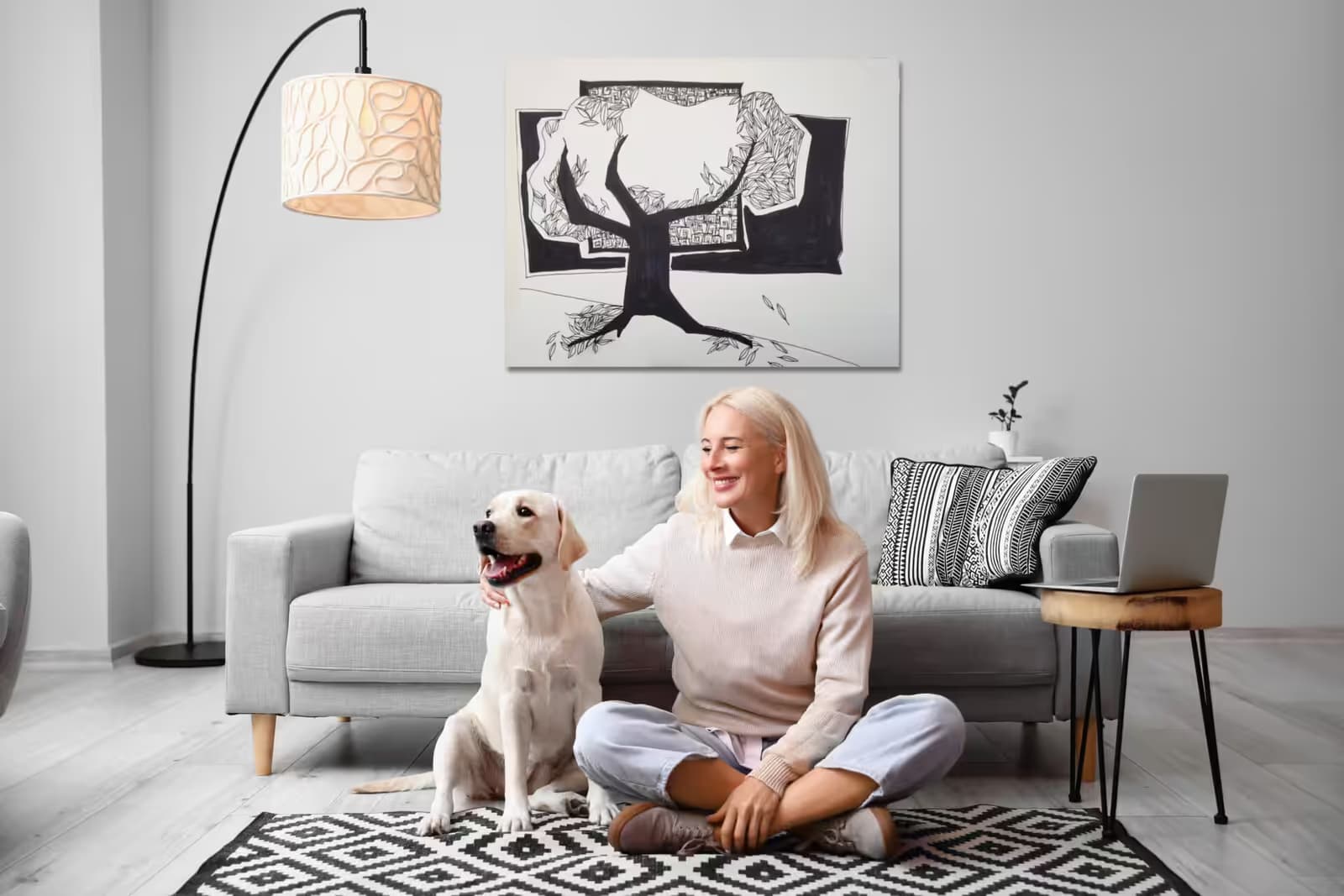 Mature woman with cute Labrador dog near sofa at home